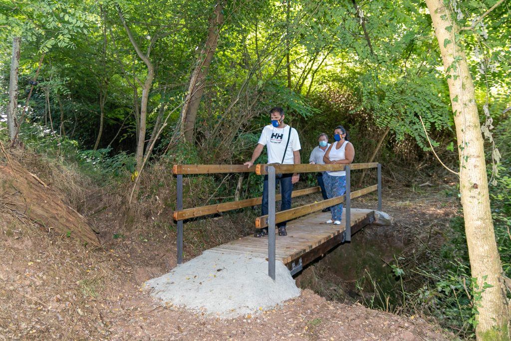 Los concejales de Medio Ambiente, Barrios y Empleo, Isabel Herrera Landeras, Fernando Sañudo Pérez y Pedro Roca Galnares, visitando el puente peatonal en el sendero al Pozo Tremeo