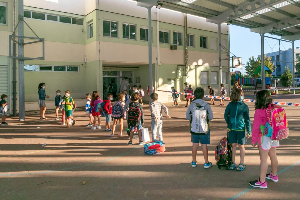 Niños esperan para acceder al colegio Pérez Galdós, de Requejada, cuya limpieza y desinfección se ha reforzado