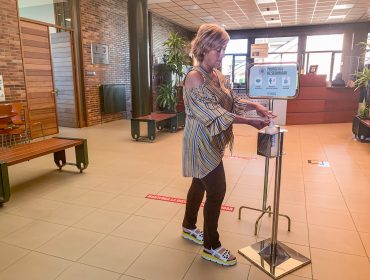 La alcaldesa, Rosa Díaz Fernández, utiliza el dispensador de geles hidroalcohólicos instalado en el vestíbulo del Ayuntamiento