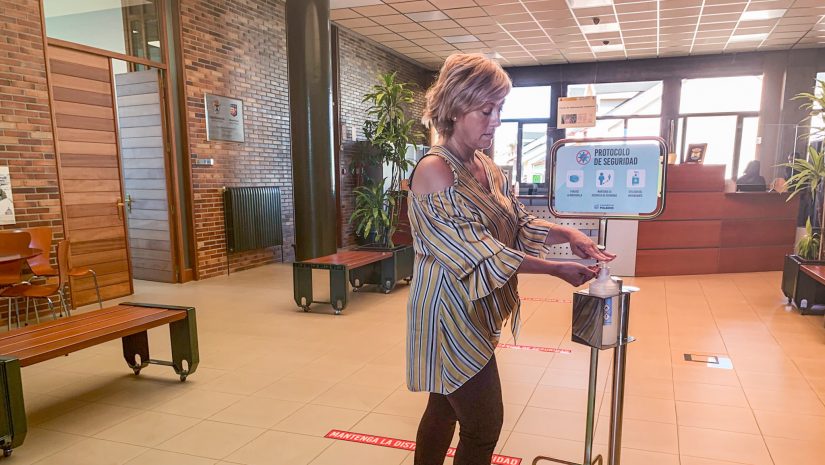 La alcaldesa, Rosa Díaz Fernández, utiliza el dispensador de geles hidroalcohólicos instalado en el vestíbulo del Ayuntamiento