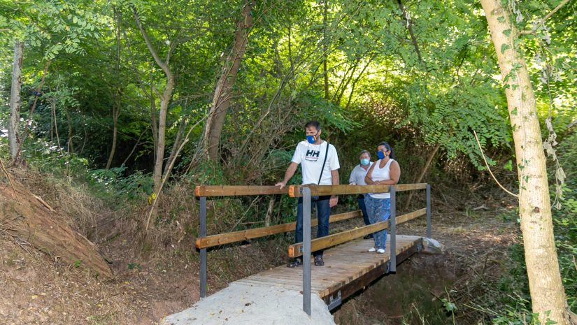 Los concejales de Medio Ambiente, Barrios y Empleo, Isabel Herrera Landeras, Fernando Sañudo Pérez y Pedro Roca Galnares, visitando el puente peatonal en el sendero al Pozo Tremeo