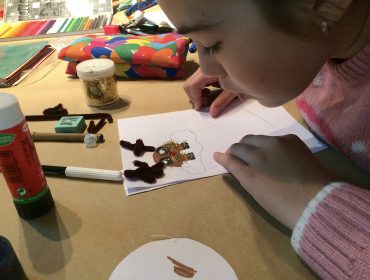 Un niño realiza una actividad cultural en la biblioteca municipal de Polanco