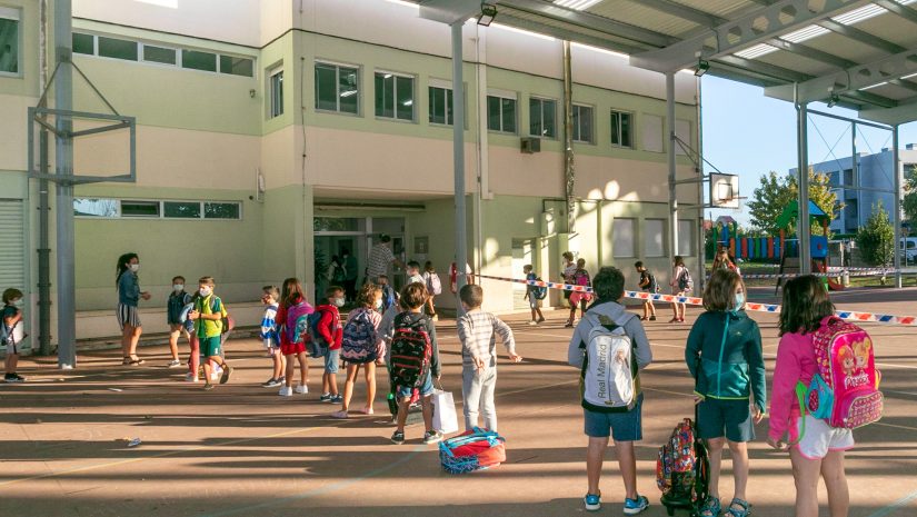 Niños esperan para acceder al colegio Pérez Galdós, de Requejada, cuya limpieza y desinfección se ha reforzado