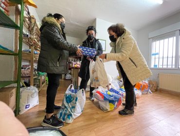 La concejal Isabel Herrera y una voluntaria de la Asociación Solidaria entregan los juguetes a una usuaria del programa de Servicios Sociales