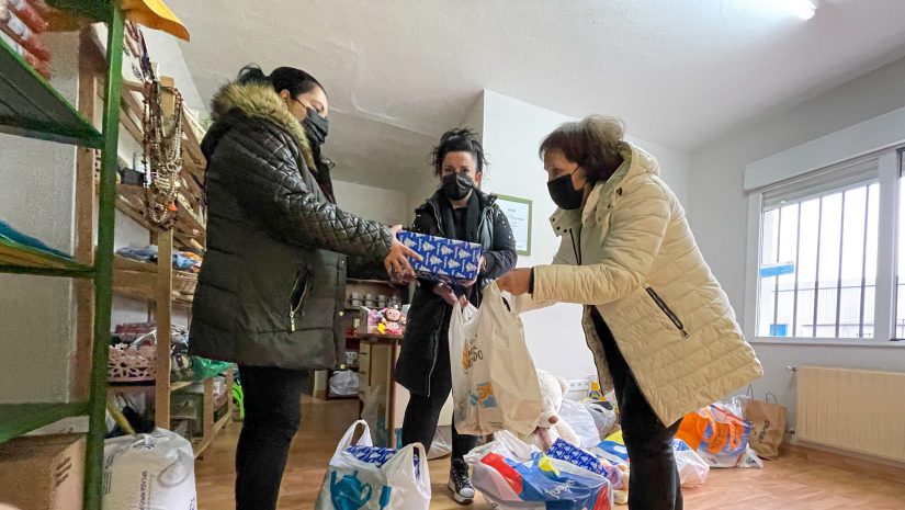 La concejal Isabel Herrera y una voluntaria de la Asociación Solidaria entregan los juguetes a una usuaria del programa de Servicios Sociales