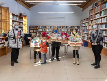 La alcaldesa y la responsable de la biblioteca con los Ganadores de las cestas de la iniciativa “Leer tiene premio”