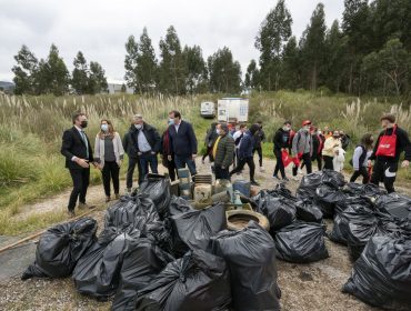 El consejero Guillermo Blanco junto a los voluntarios en la limpieza de la ría de Requejada