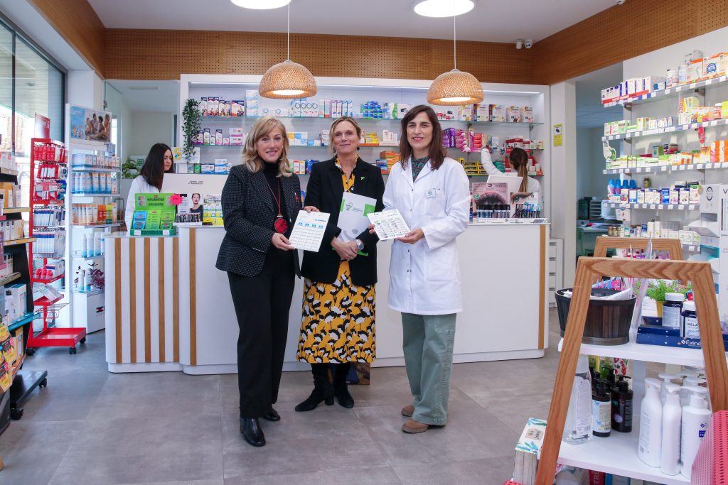 La alcaldesa de Polanco, Rosa Díaz, junto a la decana del Colegio de Farmacéuticos de Cantabria, Rita de la Plaza Zubizarreta, y la responsable de una de las farmacias del municipio muestran el pastillero gigante