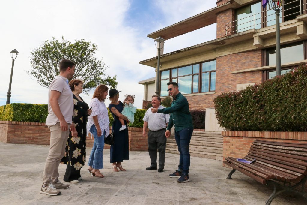 El mago Raúl Alegría hace un truco ante la alcaldesa y varios vecinos de Polanco